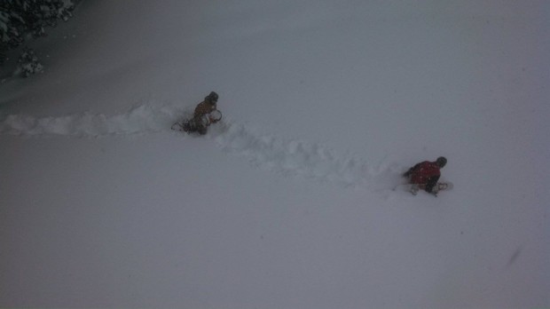 Snowboarders trenching through the waist deep in Granite Chief