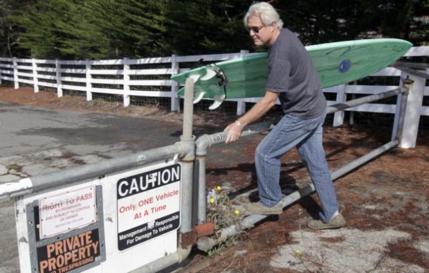 Mark Massara, one of the attorneys representing the Surfrider Foundation, hops a gate to Martins Beach in Half Moon Bay, Calif. on Thursday, Sept. 25, 2014, which remained locked despite a judge's order to landowner Vinod Khosla to to open the private gate and allow public access to the beach. Photo: Paul Chinn / The Chronicle