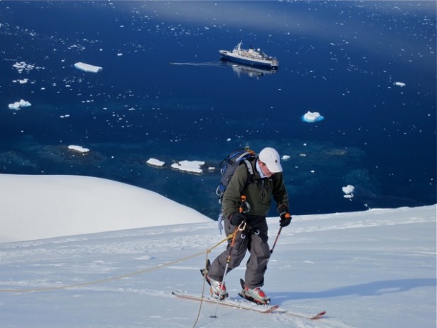 Client Bruce Cummings skinning up the glacier with the Sea Adventurer below. photo: Chris Davenport