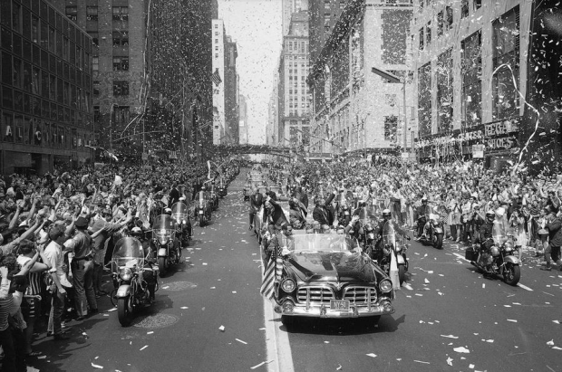 New Yorkers line 42nd Street to cheer Apollo 11 astronauts on August 13, 1969. In lead car from left are: Edwin Aldrin, Michael Collins and Neil Armstrong, who return the greeting with waves. Motorcade is traveling East on 42nd street, towards the United Nations building. #