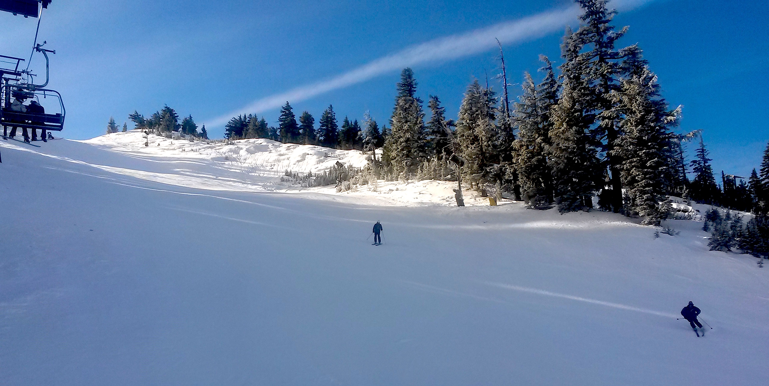 Skiers enjoying the empty groomed runs in the sunshine