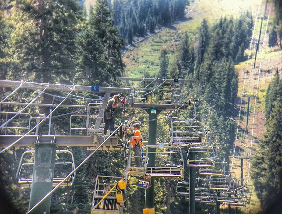 Lift mechanics, lift maintenance, working on a lift, men in black