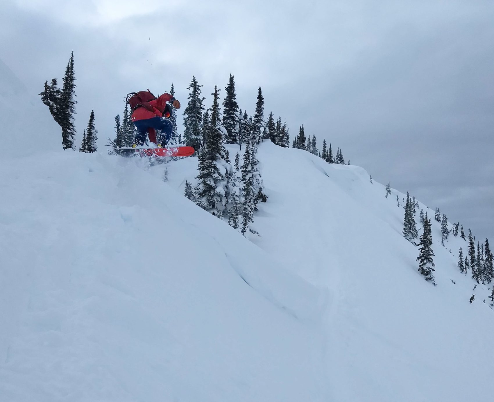 snowboarder launching off cornice