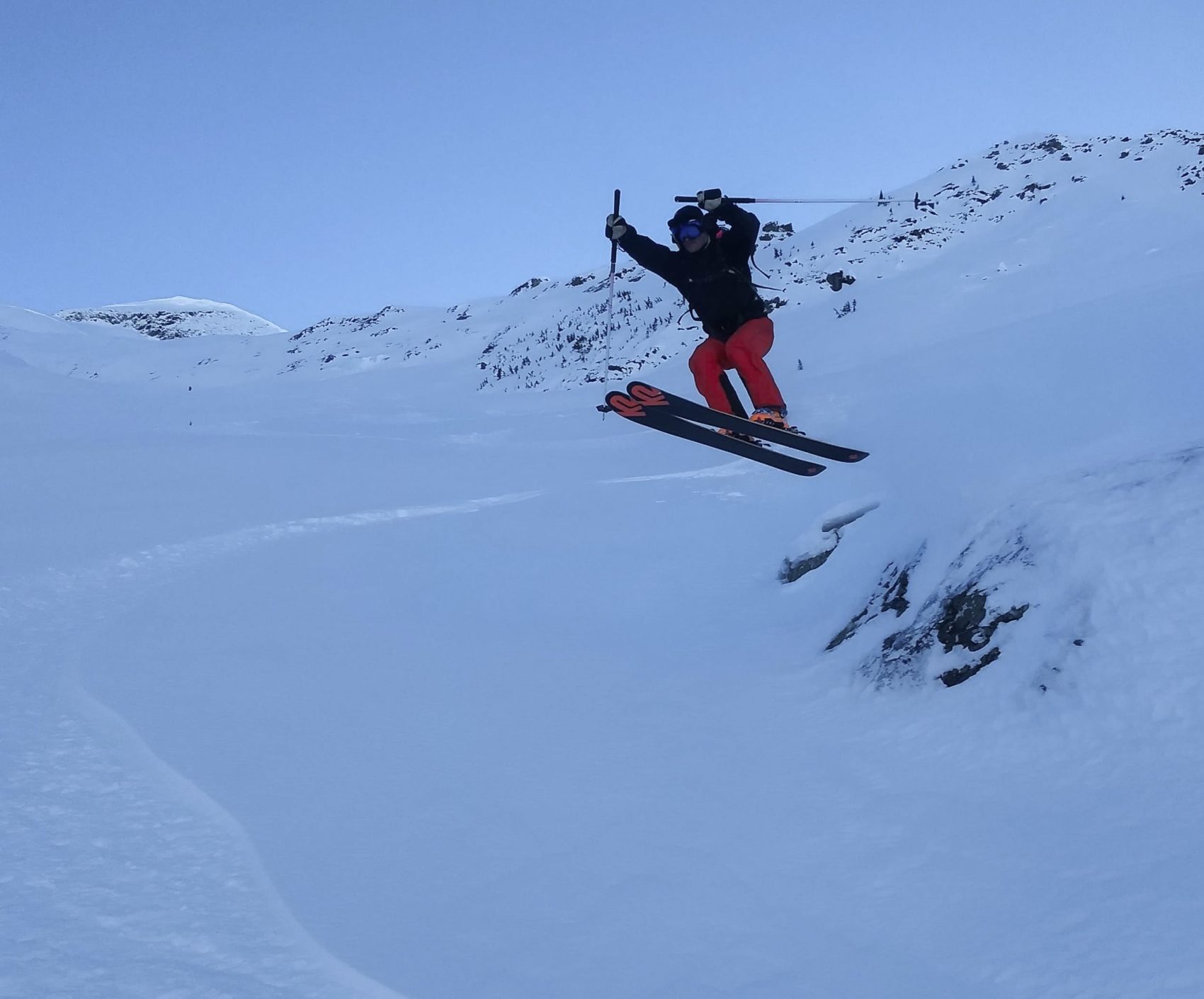 skier leaping off boulder