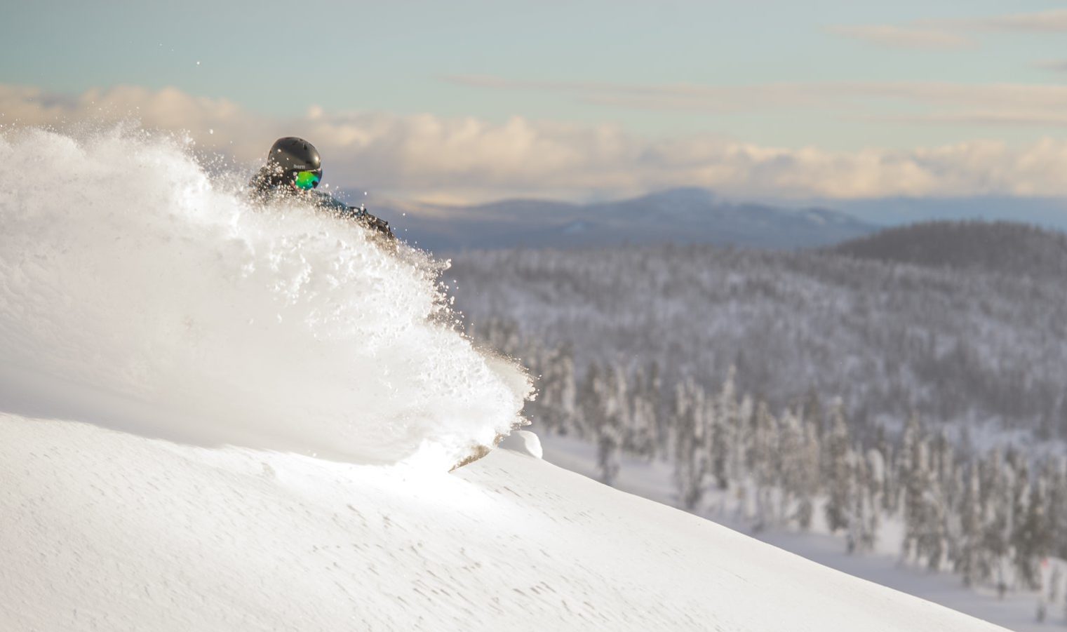 snowboarding in deep powder snow at big white ski resort in british columbia