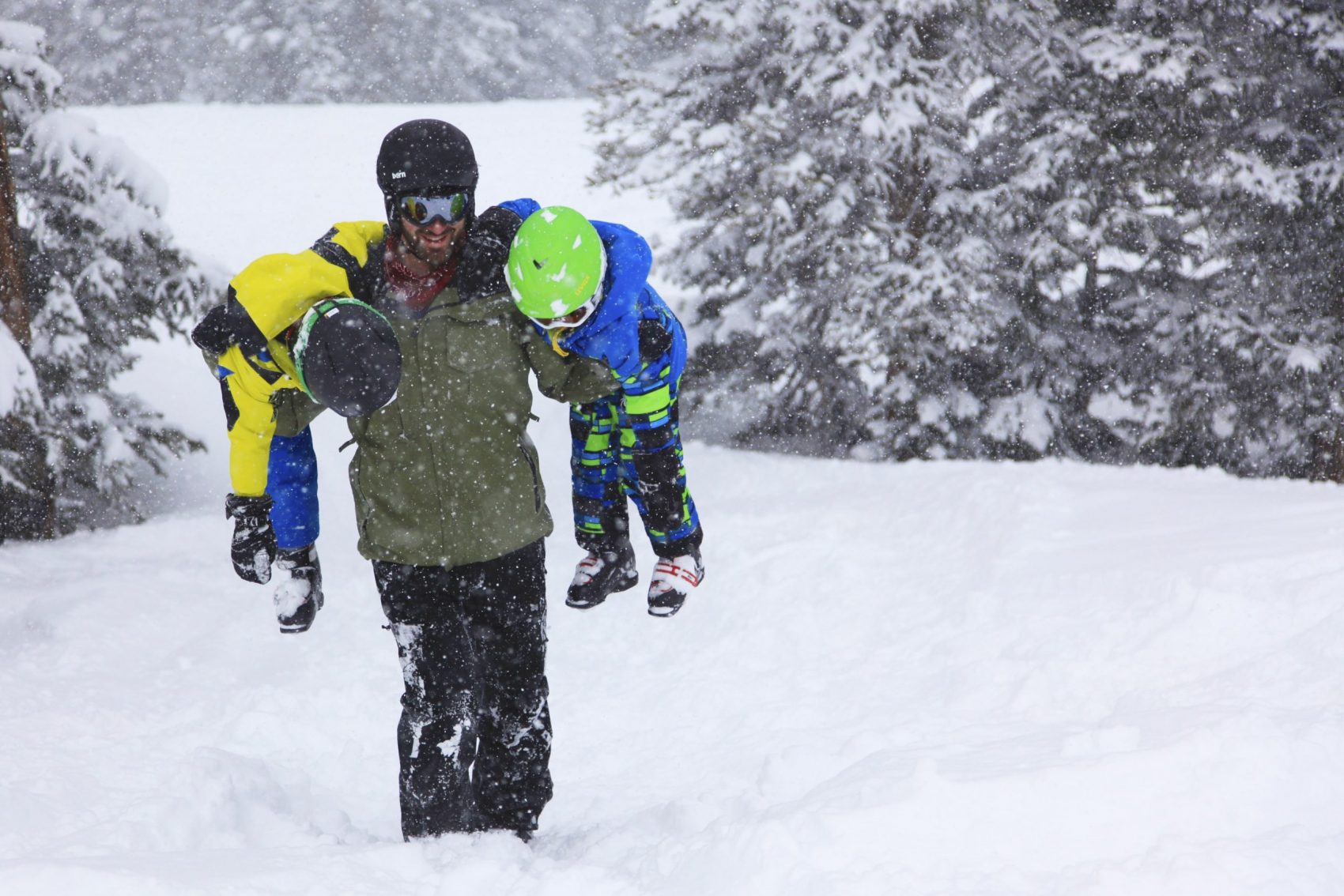 ski instructor carrying kids