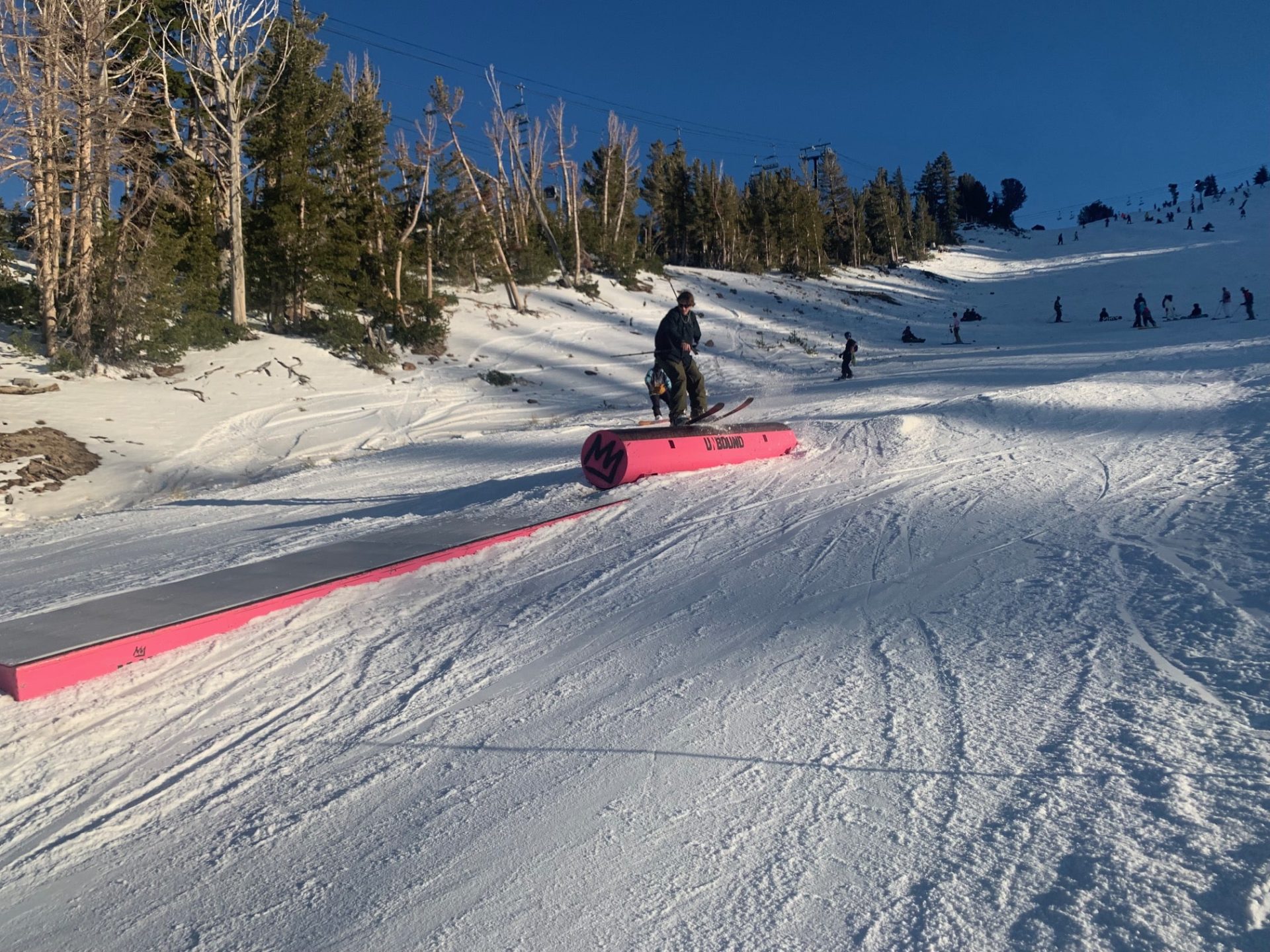 Skier slides a tube with a box following. At Mammoth, CA.