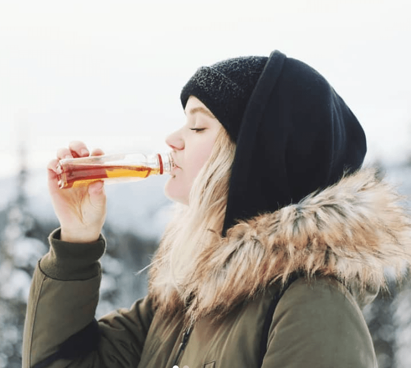 Skier drinking Fireball while skiing