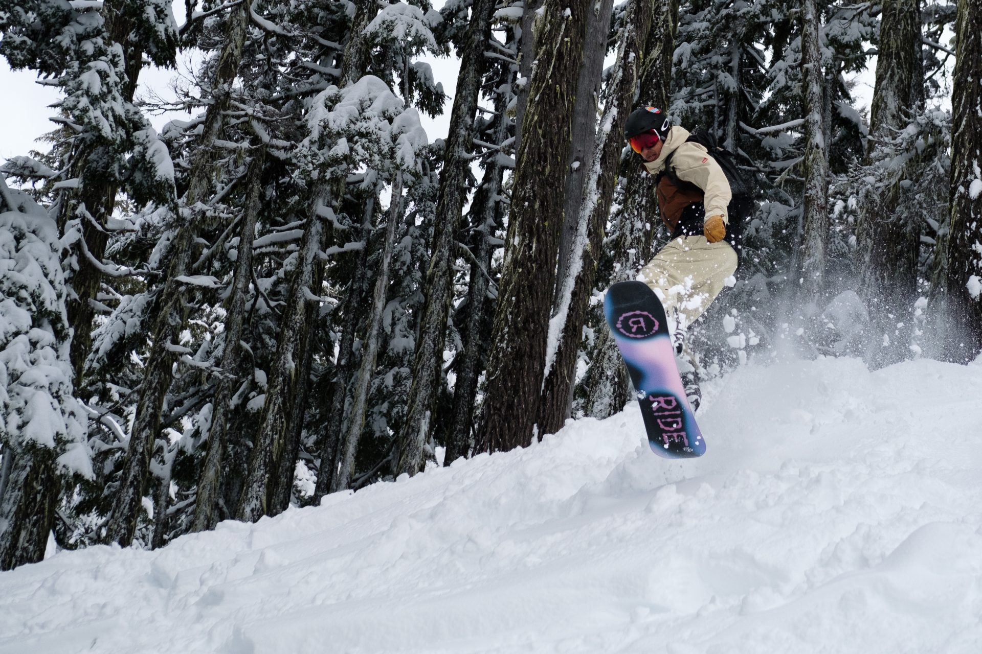snowboarder in the air with trees in the background at mt. bachelor