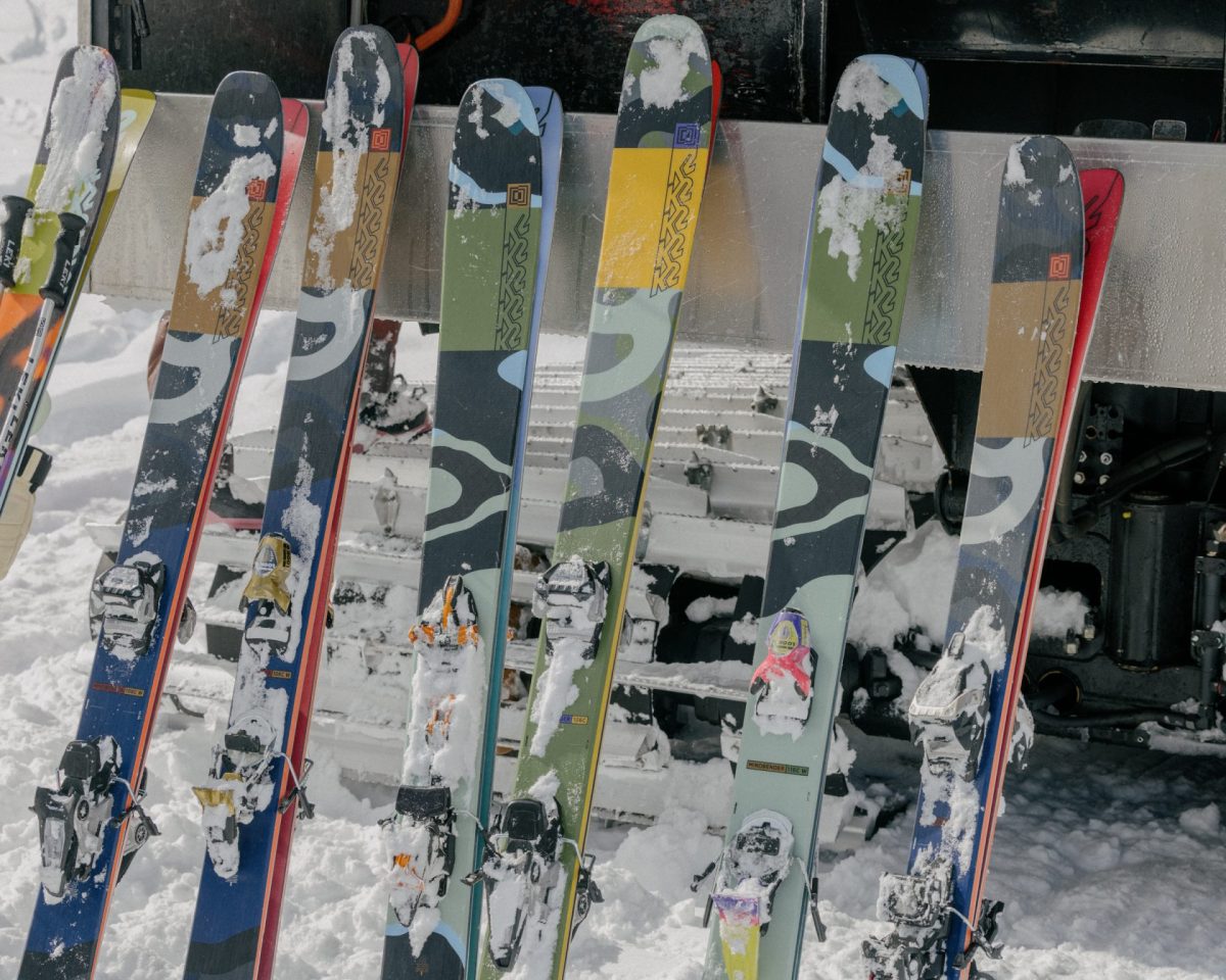 A lineup of K2 skis on a ski rack.