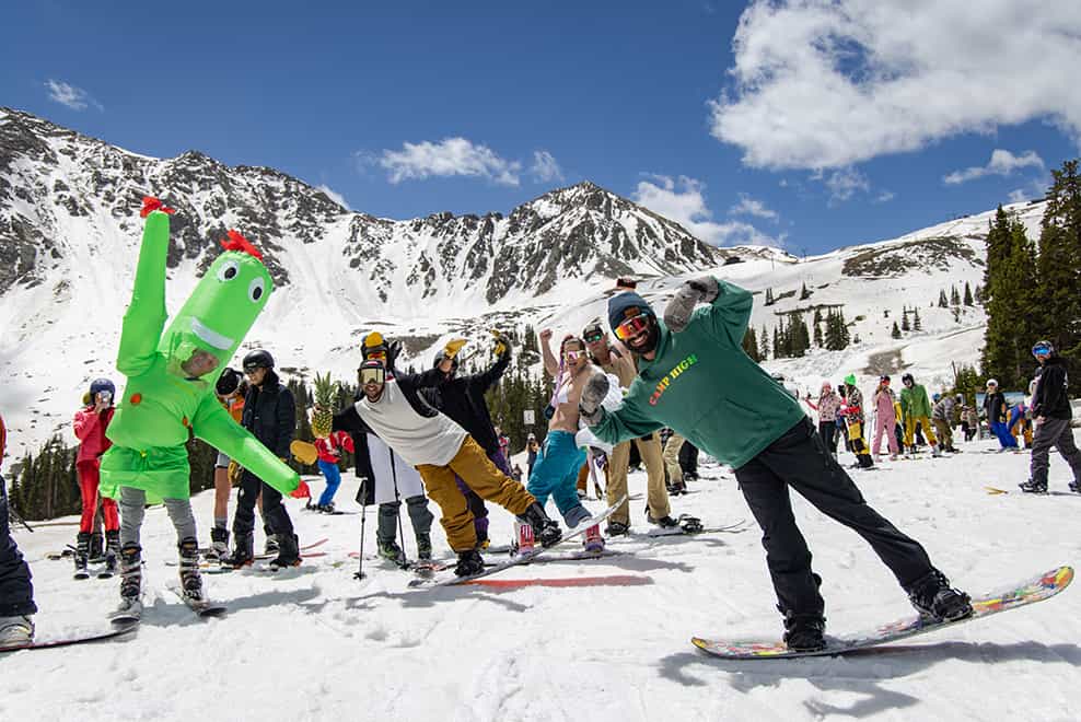 skiers and snowboarders celebratin gin fancy dress on the snow