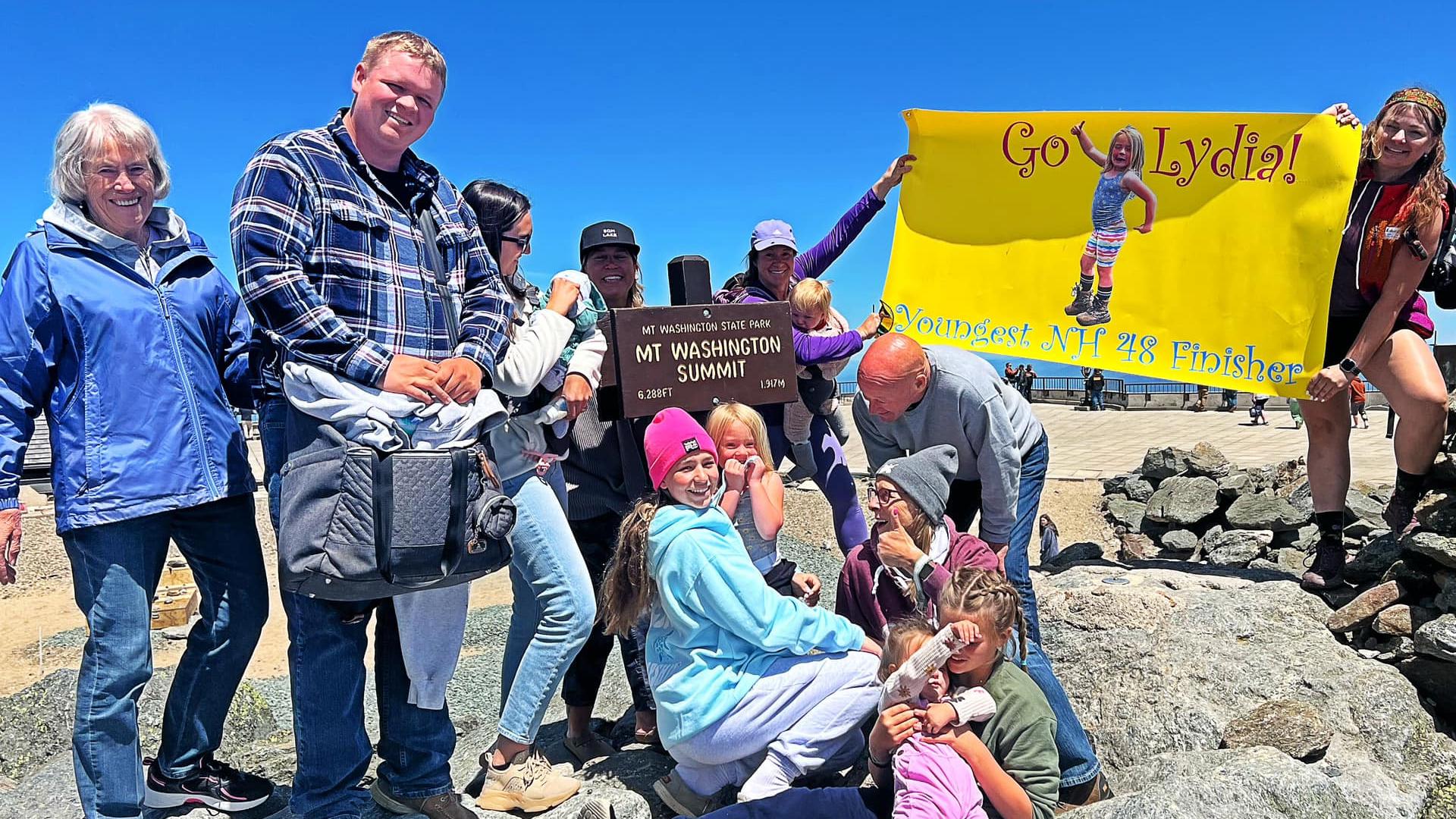 People celebrating a young hiker's record breaking achievement