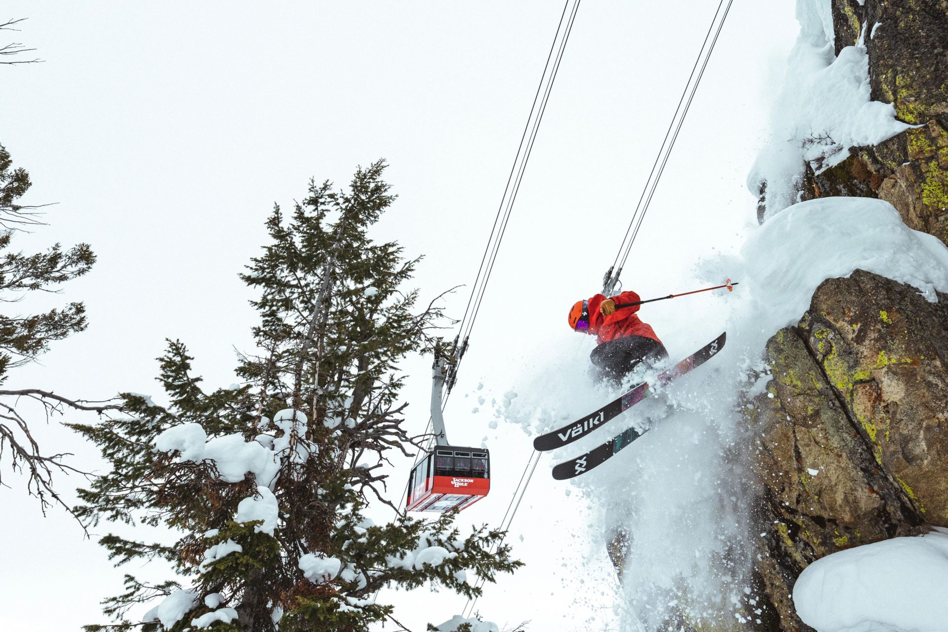 Skier jumping off a cliff underneath the Jackson Hole tram